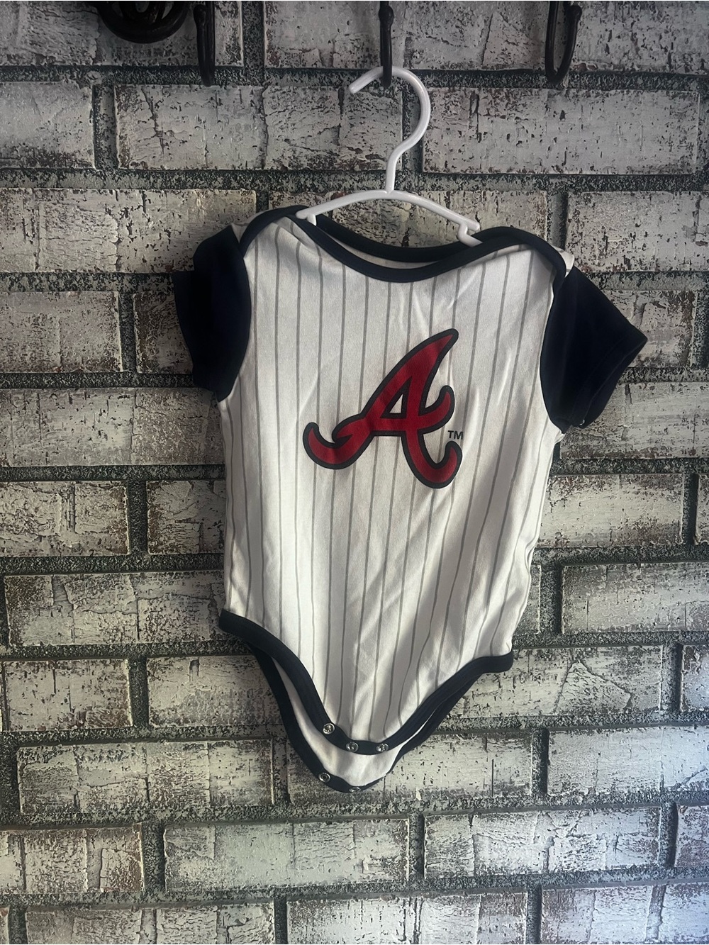Genuine Merchandise White and Black Baby One-Piece with Red 'A' Logo